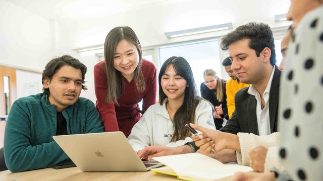MBA students sitting around a laptop