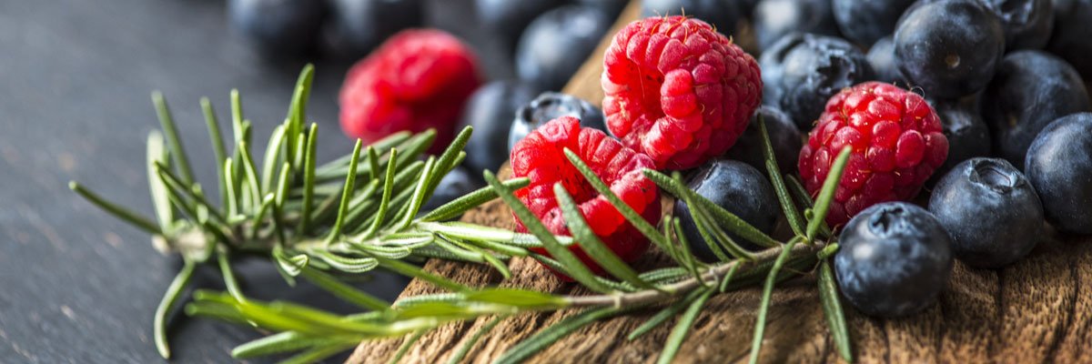 Board with raspberries and blueberries on it