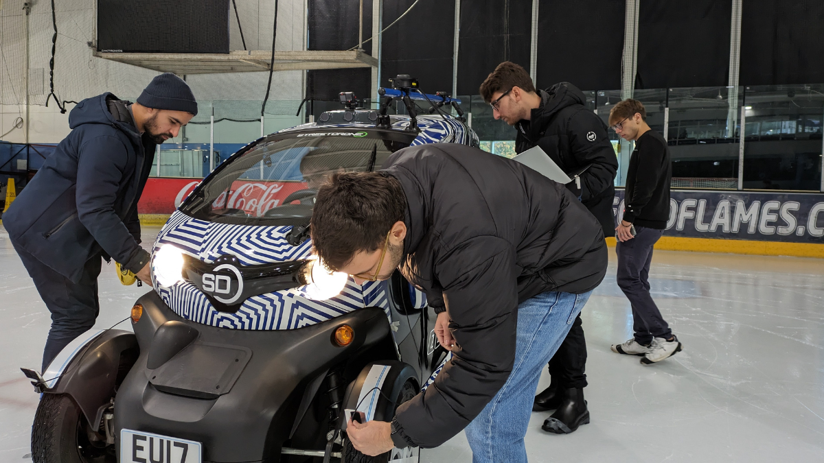The team prepares the autonomous car to drive on the ice rink