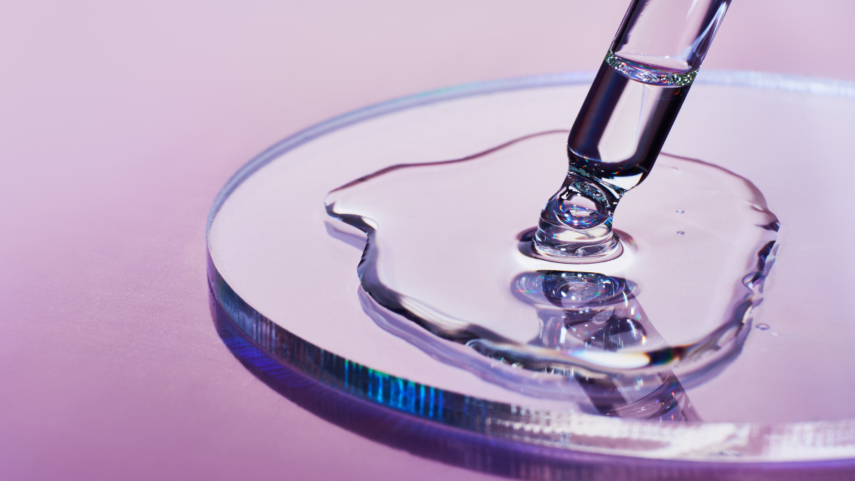 Stock image of a pipette injecting a clear substance onto a petri dish. 