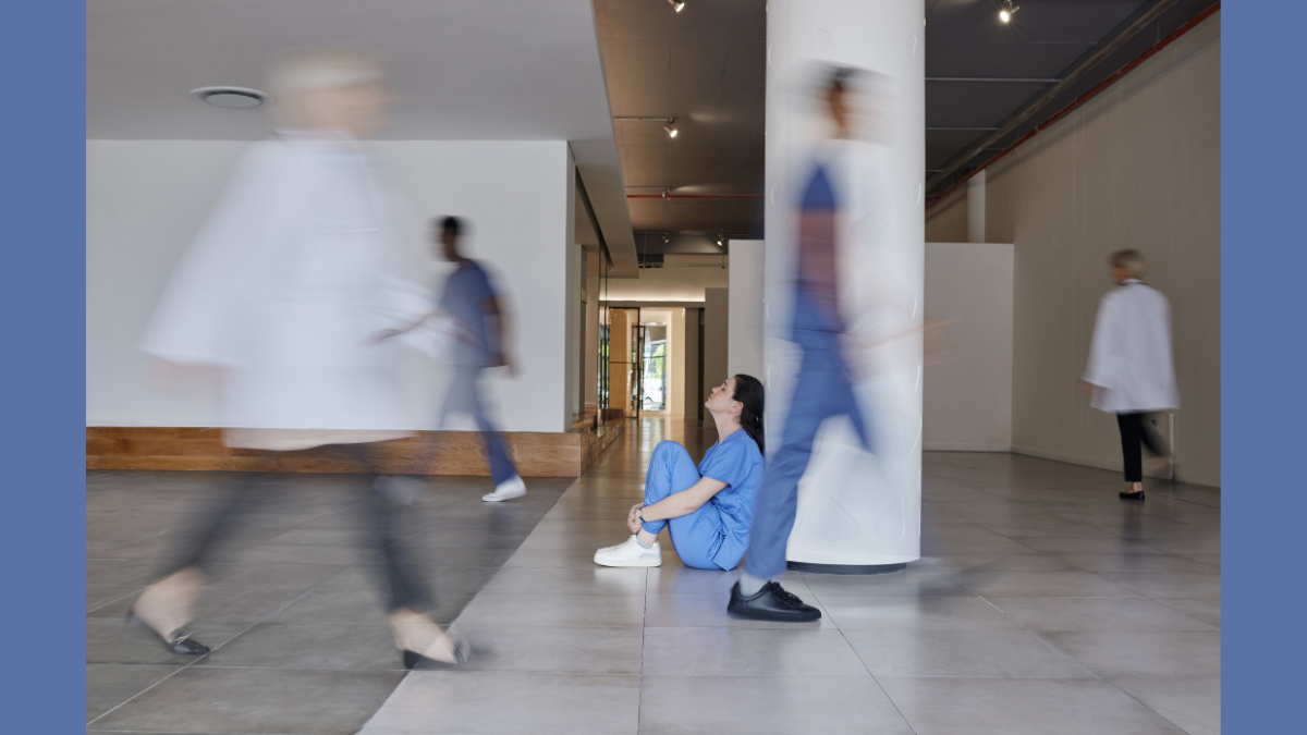 GettyImages - Nurse sitting on the floor while people walk by