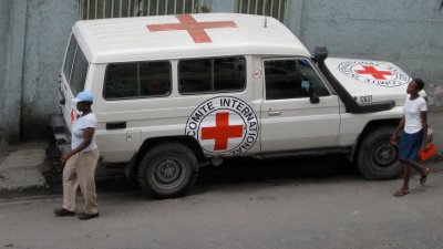 Two women walking alongside an ambulance