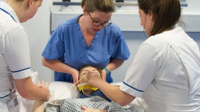 A nurse with a patient on a bed