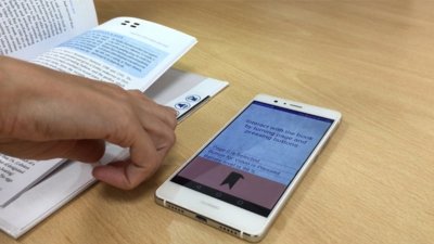 Mobile on a desk with book next to it