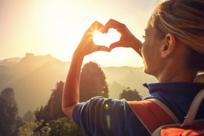 Sustainable tourism image with woman making heart-shape with hands