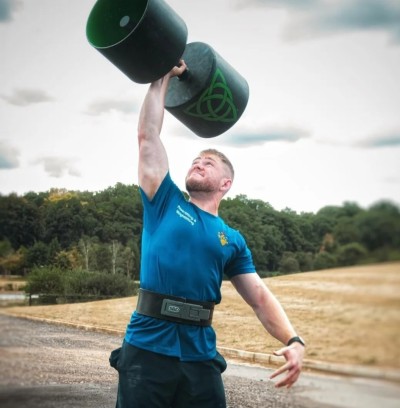 Surrey Economics and Maths graduate, Nick Green, lifting weight above his head