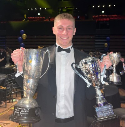 Ewan Taylor, Economics and Finance UG, holding sports trophies