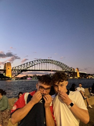 Economics student Edgar Crook with friend by Sydney Harbour at dusk