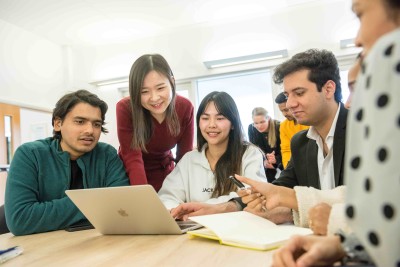 MBA students sitting around a laptop