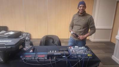 University of Surrey Film Production and Broadcasting Engineering student, Henry, in front of sound recording kit on his summer internship in Johannesburg, S Africain a large room