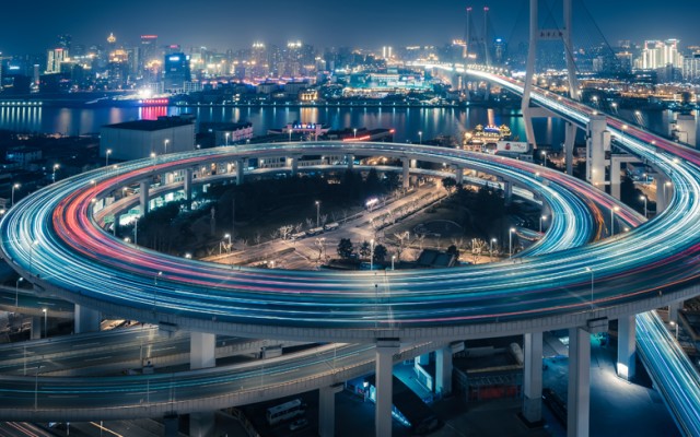A view of urban traffic flowing through a city at night