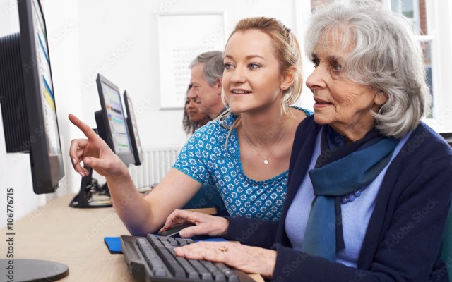 older lady and teacher a computer