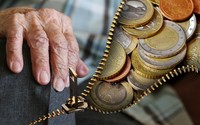 Older persons hand and money in coins