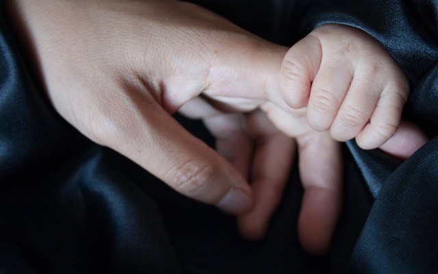 Young and older hands touching