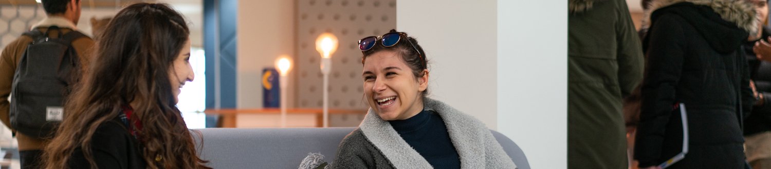 Two females smiling and laughing together in the new Surrey Hive support centre.