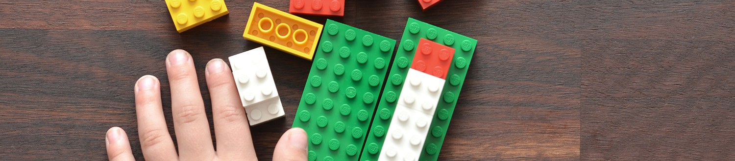 a child's hand with Lego bricks