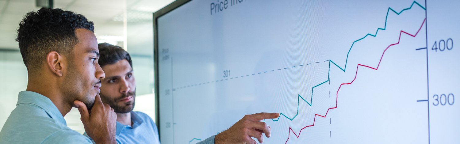 Two males looking at board