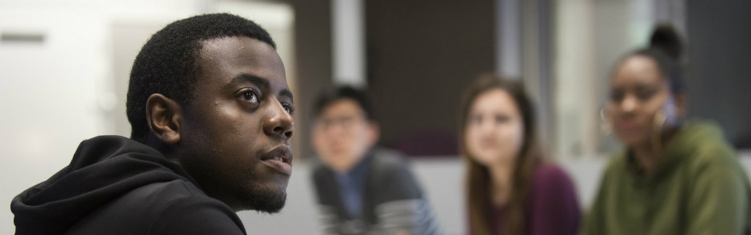 A male student listening in a seminar