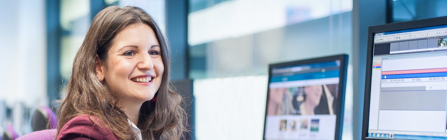 Woman sat a computer smiling