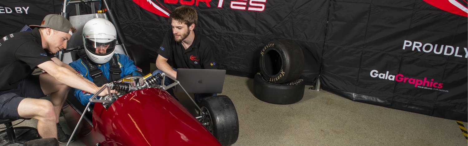 Students working a formula one car