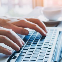 Male hands typing on laptop