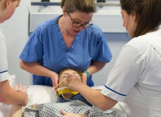 A nurse with a patient on a bed