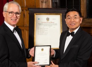 Professor Simon de Lusignan receives a framed certificate from Professor Max Lu
