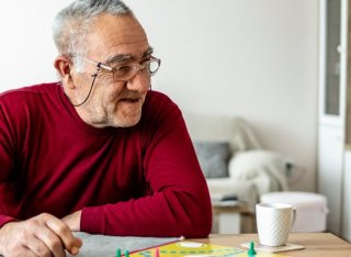 Two elderly people play a board game together 