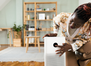 woman switches on a smart speaker in her living room