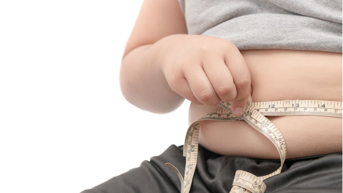 Person wrapping tape measure around their stomach