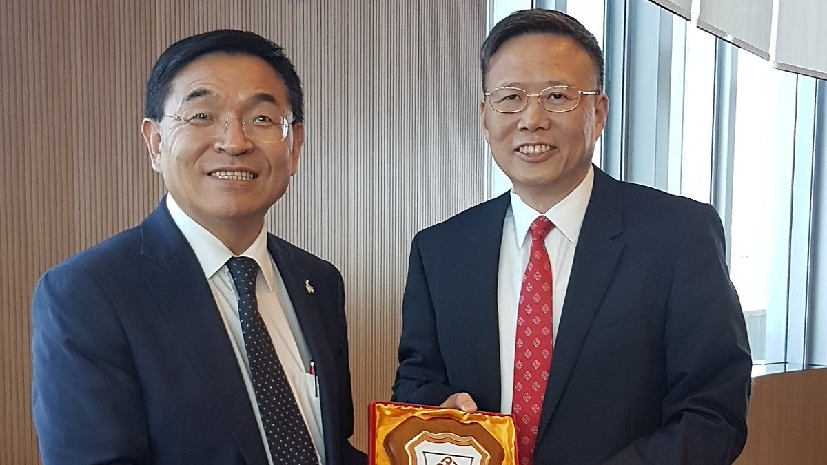 Professor Jin-Guang Teng, President of PolyU (right) presents a souvenir of PolyU’s School of Hotel and Tourism Management to Professor G.Q. Max Lu, President and Vice-Chancellor of the University of Surrey