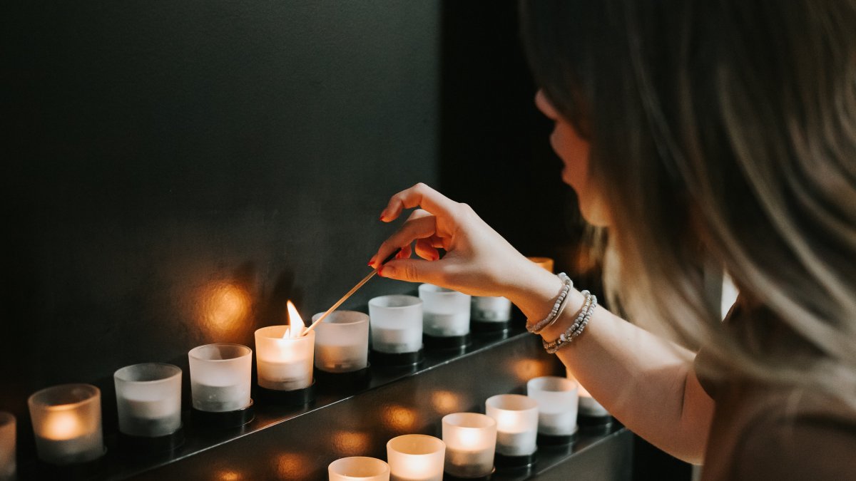 Woman lighting candle for Holocaust Memorial Day