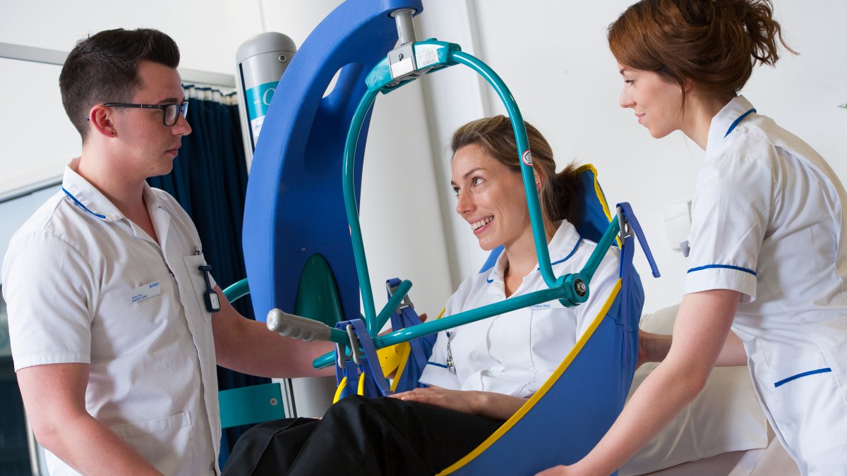 Nursing student being lifted in a mobile crane