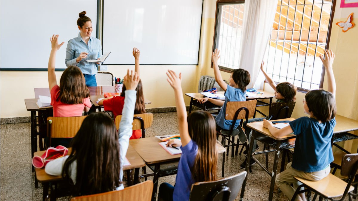 School children with their hands up in classroom