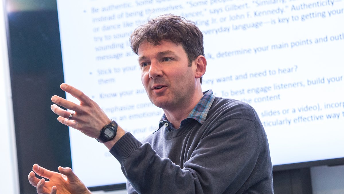 Dr Adrian Banks teaching in front of a whiteboard