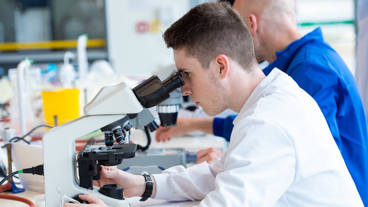 Student looking down a microscope