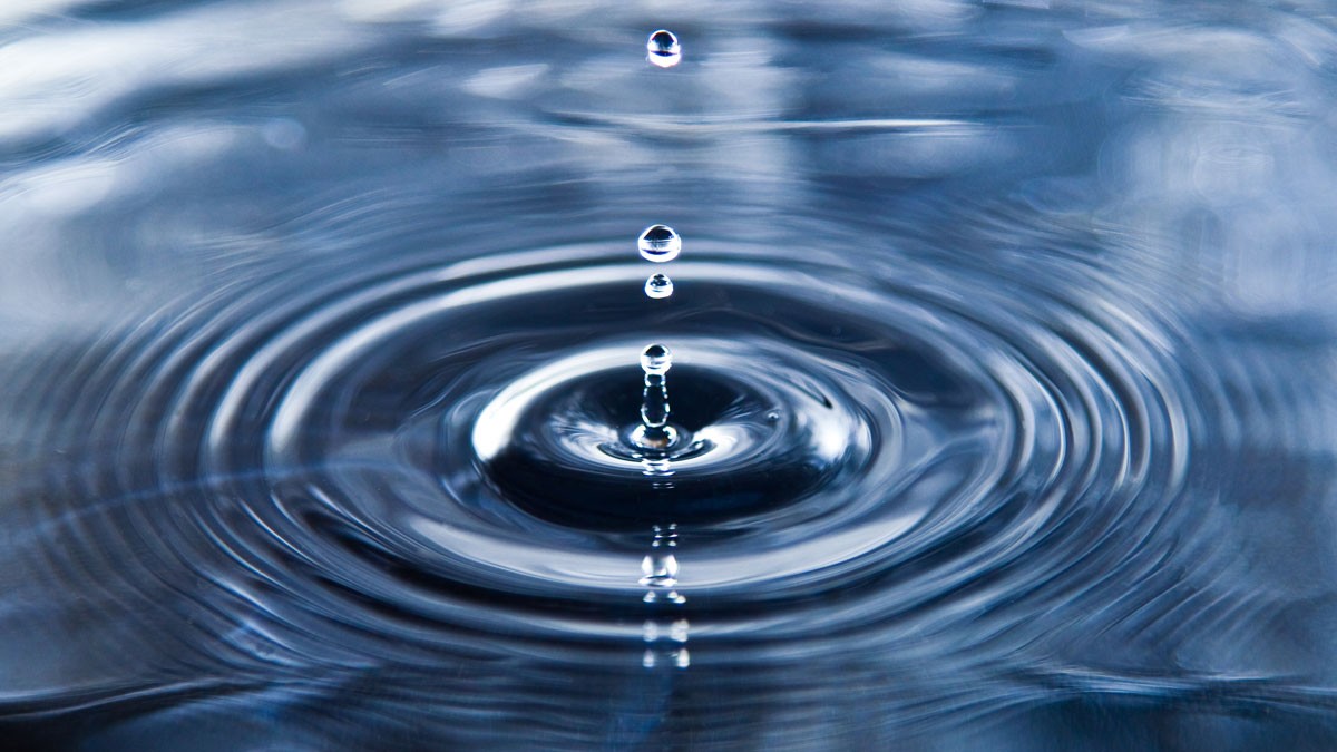 Water droplets falling into lake causing a ripple effect.