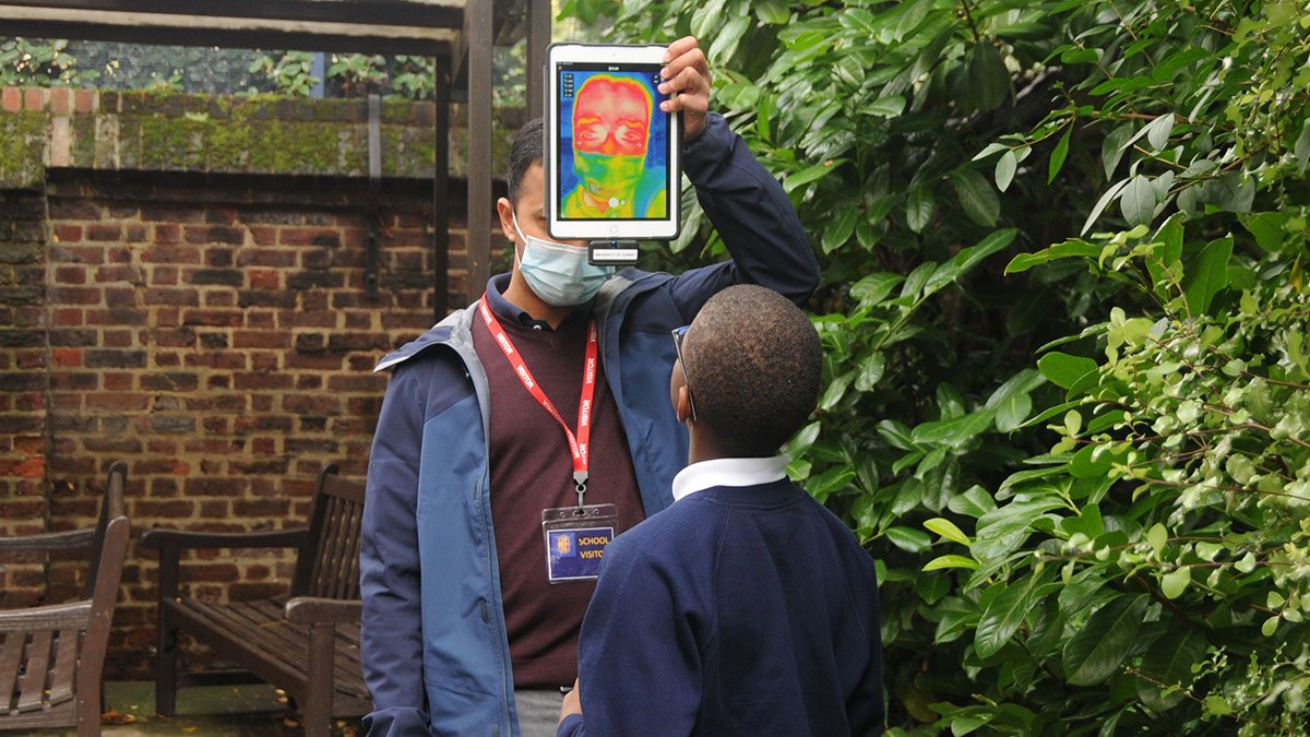 School child looking at Heat-Cool image held by GCARE researcher