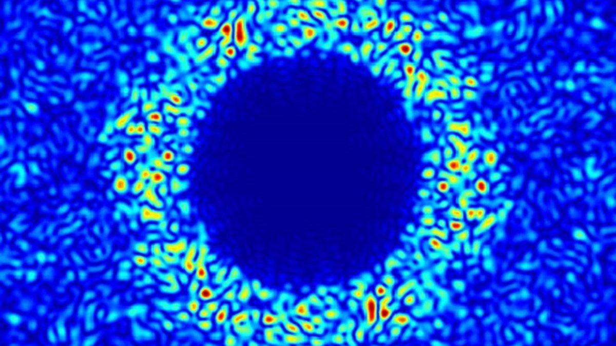 A blue circle with lighter blue pattern around it which shows light scattering from a thin silicon membrane