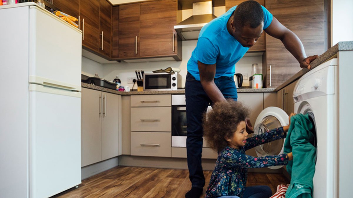 Father and young son loading the washing machine