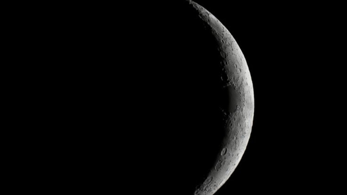 A sliver of Moon visible in the night sky