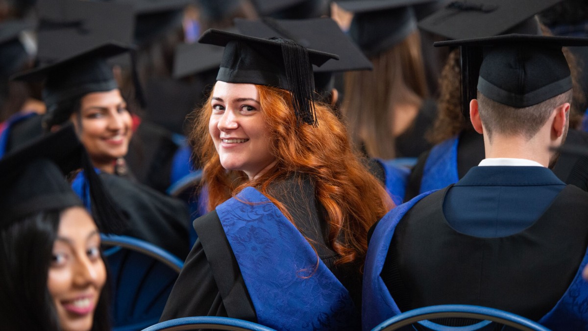 Surrey graduand turning around in graduation ceremony audience