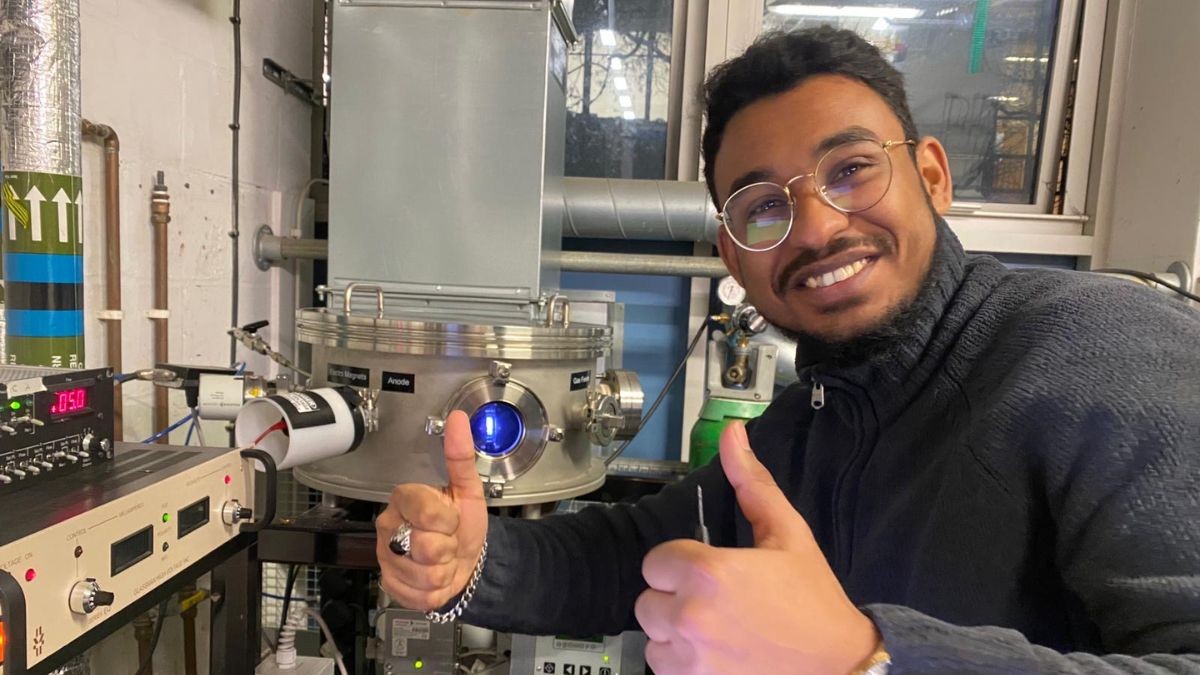 Moe Ahmed smiles and gives two thumbs up in Surrey's hi-tech Propulsion Laboratory
